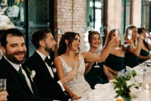 Bride, groom and wedding party cheersing with champagne